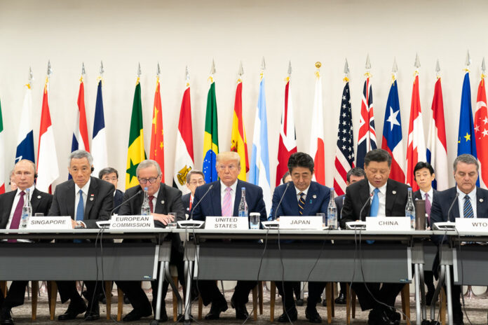 Trump Xi Jinping China - Pertemuan Trump dan Xi Jinping di China dalam ruang sidang formal dengan bendera diplomatik.